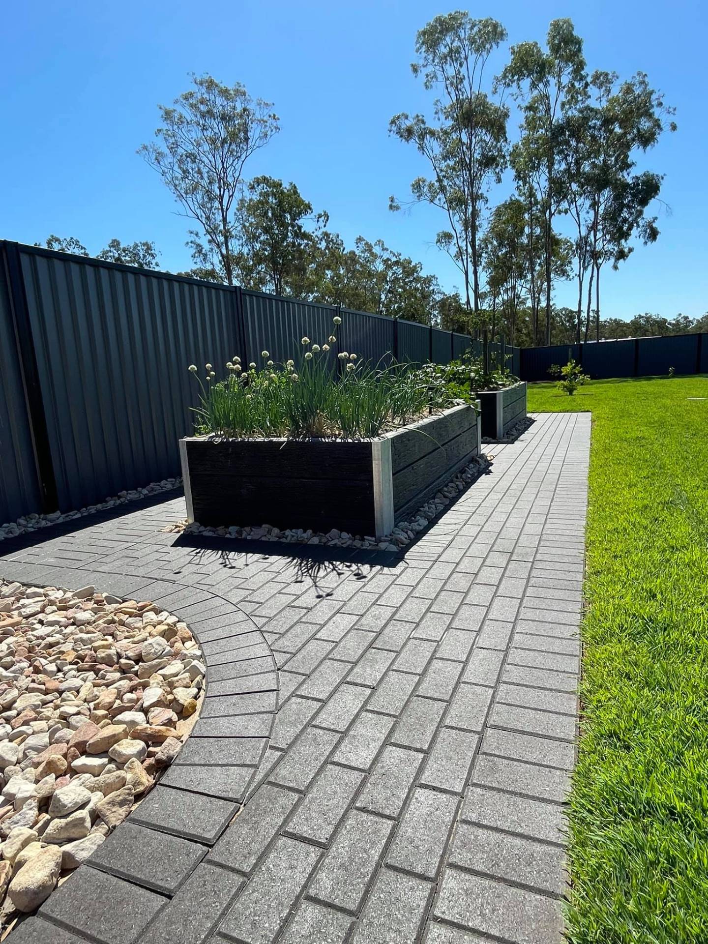 Curved paver path, raised beds & feature stone.