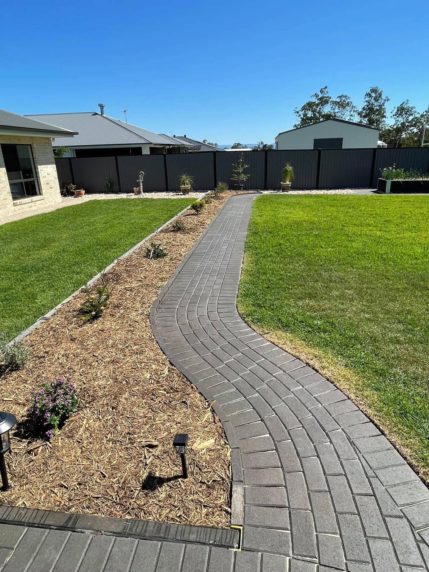Long curved paver walkway and garden border.